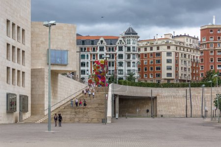 Foto de Bilbao España - 07 05 2021: Vista de los turistas caminando por el centro de Bilbao, plaza con escalera moderna, edificios clásicos en zona turística - Imagen libre de derechos