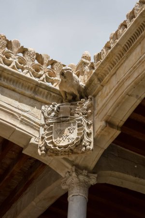 Salamanca Spanien - 05 12 2021: Detailansicht von Wasserspeier und Wappen in Stein gemeißelt, auf verziertem Kreuzgang im Casa de las Conchas Gebäude, in der Innenstadt von Salamanca, Spanien
