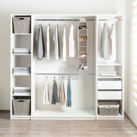 a small white walk in closet with open shelving and shelves holding baskets