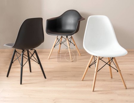 Foto de Tres sillas contemporáneas diferentes hechas de una combinación de materiales de plástico y madera - Imagen libre de derechos