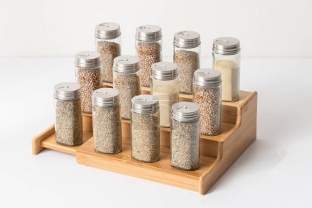 Foto de Agitadores de sal y pimienta en una bandeja de madera sobre un fondo blanco, estante de condimento de madera - Imagen libre de derechos