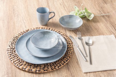 Téléchargez les photos : Ensemble de vaisselle moderne bleu clair avec assiette, cuillère et fourchette sur fond de table en bois, vue sur le dessus - en image libre de droit