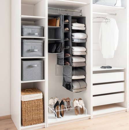White wardrobe with clothes, Shoe Rack Organizer and accessories. Modern interior design.