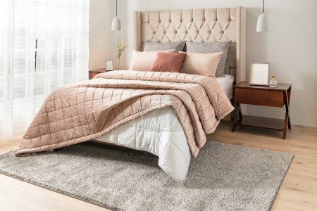 Innenraum des luxuriösen Schlafzimmers mit beige-weißem Home Velvet und Baumwolltufted Quilt, Deckenkissen auf dem Bett