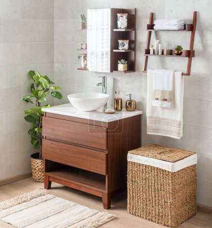 Téléchargez les photos : Intérieur de la salle de bain avec une vanité de salle de bain moderne du milieu du siècle avec un lavabo en céramique et des paniers en osier - en image libre de droit