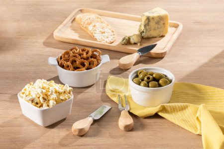 Photo for An overhead view of a white plate containing assorted snacks, including sliced olives, pretzels, and grated cheese - Royalty Free Image
