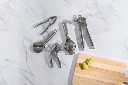 Foto de Una selección de herramientas de cocina además de una tabla de cortar de madera, vista superior - Imagen libre de derechos