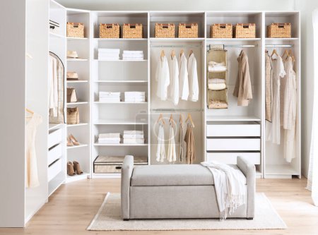 Ein gemütliches Schlafzimmer mit weißen Wänden und einem Kleiderschrank, in dem Kleidung ordentlich aufgehängt wird
