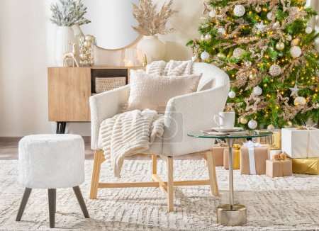Photo for Scandinavian Christmas Living Room Featuring a Christmas Tree, Presents, and a White Armchair with Matching Footstool Beside a Coffee Side Table - Royalty Free Image
