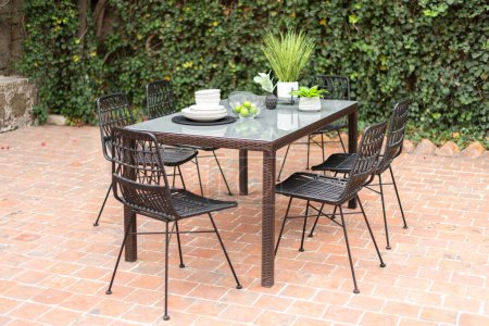 Photo for Outdoor dining set in a cozy garden setting, relaxing House patio ,Nobody - Royalty Free Image