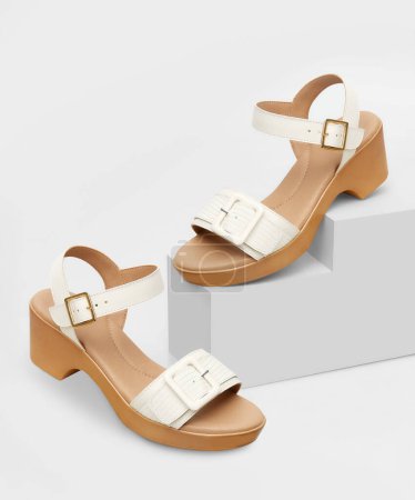 Sophisticated white textured buckle sandals for women, elegantly displayed on geometric Cubic Props, a comfortable low block heel, adjustable ankle strap with a golden buckle, and a wide front strap.