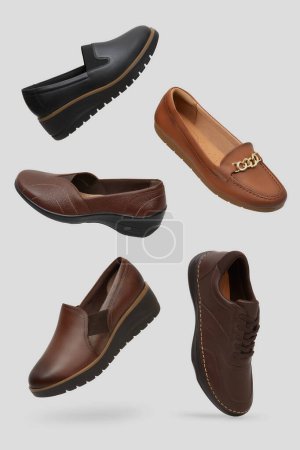 Creatively arranged floating collection of versatile daily wear shoes, a black slip-on with a serrated sole, a classic brown loafer a textured brown slip-on, and a brown leather shoe, neutral backdrop