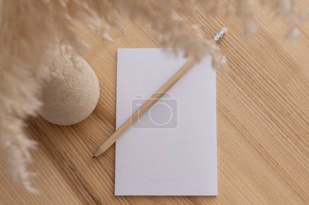 Foto de Mockup primer plano de una mesa de diseño de madera en la que hay una hoja en blanco de papel y un lápiz y una flor. Foto de alta calidad - Imagen libre de derechos