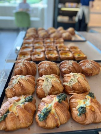 Téléchargez les photos : Délicieux petits pains au fromage et aux épinards dans une boulangerie. - en image libre de droit
