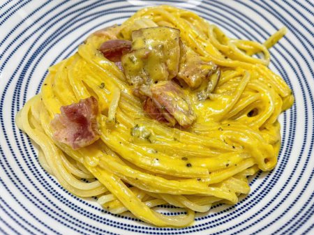 Photo for Spaghetti carbonara with bacon and cheese on a blue plate. - Royalty Free Image