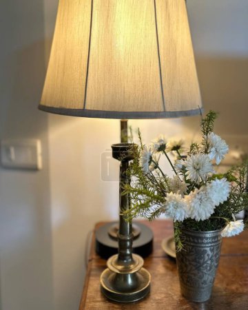 Téléchargez les photos : Lampe de table et fleur en vase sur table en bois dans le salon - en image libre de droit