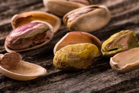 Photo for Pistachios macro with selective focus on rough wooden background - Royalty Free Image