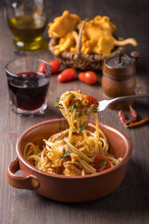 Foto de Cocina italiana: primer plano con espaguetis cocinados con tomate y rebozuelos. Plato vegetariano - Imagen libre de derechos