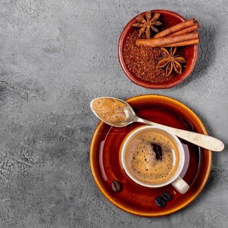 Photo for Espresso coffee in cup, flavored with cinnamon and star anise, top view on gray textured background - Royalty Free Image