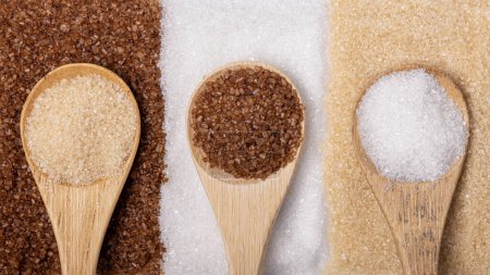 Téléchargez les photos : Différents types de sucre dans des cuillères en bambou, complet, blanc et de réglisse aromatisé - en image libre de droit