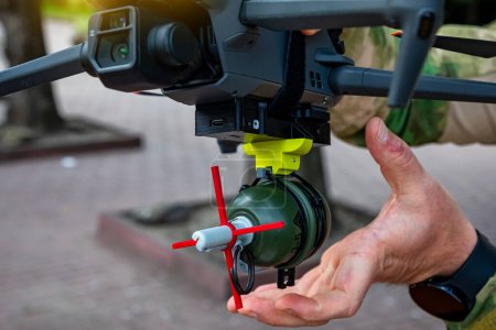 Foto de Soldado ata granada volar a un enemigo con dron militar. Concepto usando cuadrocopteros en la guerra inteligente en Ucrania. - Imagen libre de derechos