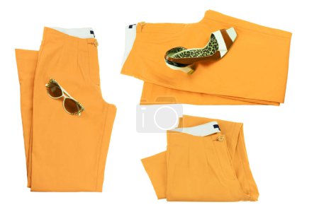Photo for Collage woman clothes. Set of folded yellow elegant women trousers or denim pants with a matching of elegant single female high heeled shoe and sunglasses. Yellow fashion concept isolated. - Royalty Free Image