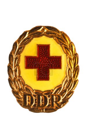 Photo for Potsdam, Germany - DEC 12, 2022. Badges, orders and medals from GDR (DDR). Close-up of a National Defence Badge of the German Red Cross in bronze. Clipping path. Macro isolated on white. - Royalty Free Image