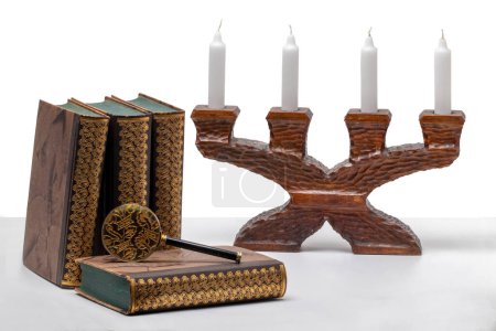 Foto de Ancient books with a magnifying glass and a antique wooden candle holder on a bright table isolated on a white background. - Imagen libre de derechos