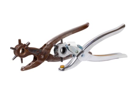 Tailor accessories. Close-up of a antique adjustable steel punch pliers and a modern hole punch tool isolated. Clipping path. Tools from tailor, saddler or cobbler.