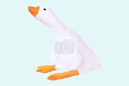 Childrens toy stuffed animals. Soft white plush toy duck for kids isolated on a light blue background. Duck teddy toy. White duck for playing.