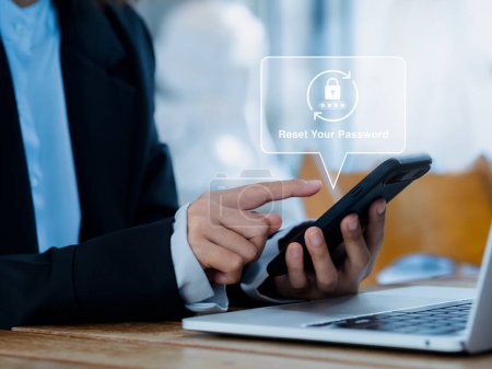 Photo for Reset password concept. Lock icon, security code showing on smart mobile phone in hands of business person while working with laptop computer in office. Cyber security technology on website or app. - Royalty Free Image