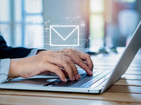 Senden von E-Mail und Business Marketing Konzepte. Schnelles Verschieben des digitalen Buchstabensymbols mit Personensymbolen, die erscheinen, während Geschäftsleute mit Laptop am Arbeitsplatz arbeiten, Nachricht senden. 