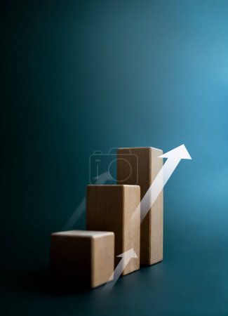 Rise up arrow on wooden cube blocks, bar graph chart steps on dark blue background with copy space, vertical style. Investment, income, inflation, business growth, economic improvement concepts.