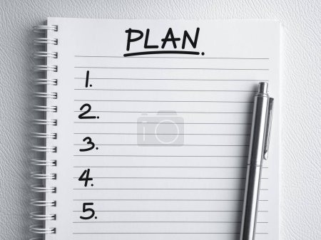 Ideas de planes de negocio, dirección de negocio y hacer lista de conceptos. Texto de escritura a mano, "PLAN" con elemento vacío 1 a 5 y pluma en la página de cuaderno en espiral con línea, fondo blanco con espacio de copia, vista superior.