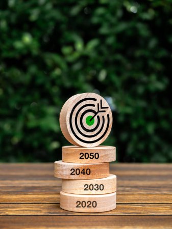 Téléchargez les photos : Zéro net d'ici 2050. Réduire les émissions de CO2, réduire le dioxyde de carbone, limiter le changement climatique, concept de réchauffement climatique. Icône de cible verte sur la pile de blocs de bois ronds avec 2020 à 2050 ans sur fond de bois. - en image libre de droit