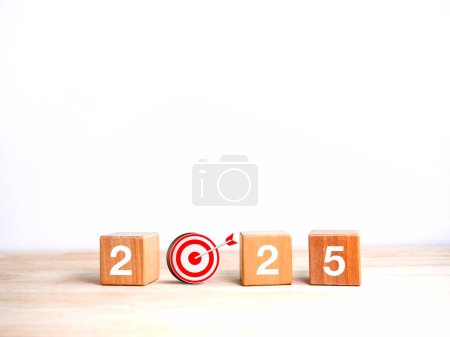 2025 Happy new year background banner. Numbers on wooden cube blocks with 3d target dart icon on wood table and white background with copy space. Business goal plan, objective and resolution concept.