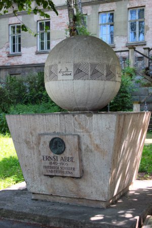 Foto de Jena, Alemania - 26 de mayo de 2023: Monumento al físico y científico óptico Ernst Abbe frente a la Universidad de Jena muestra su fórmula para el límite de resolución del microscopio. - Imagen libre de derechos