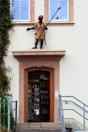 Foto de Hohenstein-Ernstthal, Alemania - 5 de junio de 2023: Esculturas decorativas de negros y guerreros africanos en la fachada de una farmacia en Hohenstein-Ernstthal, Sajonia - Imagen libre de derechos