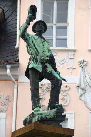 Foto de Schneeberg, Alemania - 26 de marzo de 2024: Fuente Bergmannsbrunnen con escultura de un minero en el centro de Schneeberg, una histórica ciudad minera en las montañas Minerales, Sajonia - Imagen libre de derechos
