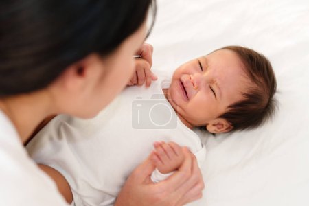 Photo for Mother with newborn baby crying on a bed - Royalty Free Image