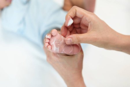 Photo for Mother applying moisturizing cream on foot of her newborn baby - Royalty Free Image