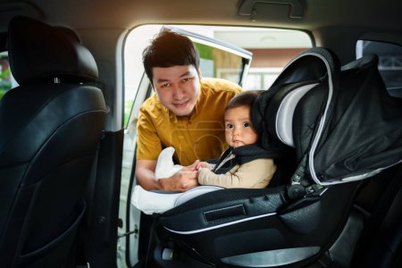 Photo for Father take care his infant baby in the car seat - Royalty Free Image