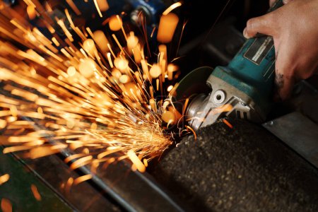 worker using angle grinder machine to grinding the metal