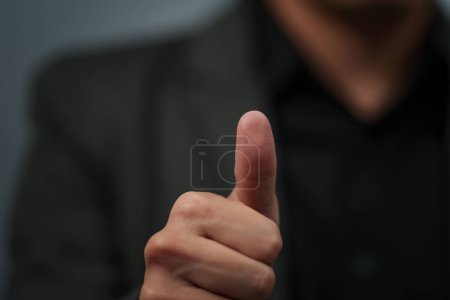 Téléchargez les photos : Businessman in a suit showing thumbs up sign or fingerprint scan - en image libre de droit