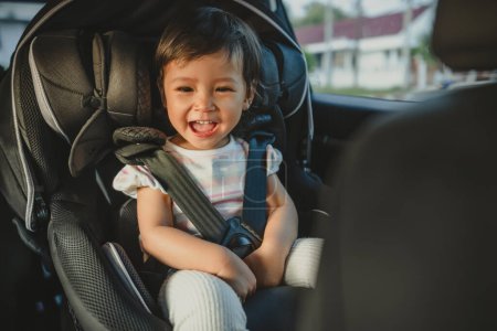 Photo for Happy toddler girl sitting in a car seat, safety baby chair travelling - Royalty Free Image