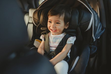Photo for Happy toddler girl sitting in a car seat, safety baby chair travelling - Royalty Free Image