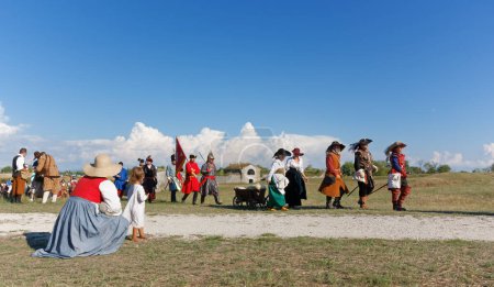 Photo for PALMANOVA, Italy - September 4, 2022: A woman and a small girl watching reenactors parading after the battle during the Seventeenth Century annual historical reenactment - Royalty Free Image