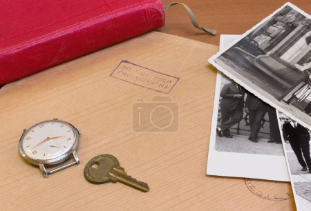 Photo for Desktop with an envelope for photographs, a few old photos, a key, a vintage watch and a book with a red cover - Royalty Free Image