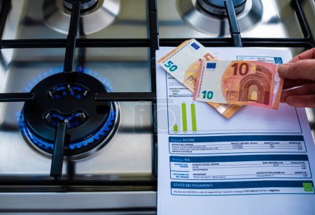 Photo for Gas burner on and in the background 10 Euro banknotes being pulled out. The concept of a steep rise in gas prices. Selective focus - Royalty Free Image