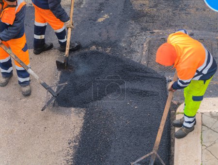 Téléchargez les photos : Travailleur sur la machine de pavage asphalte pendant les travaux de réparation de la rue - en image libre de droit
